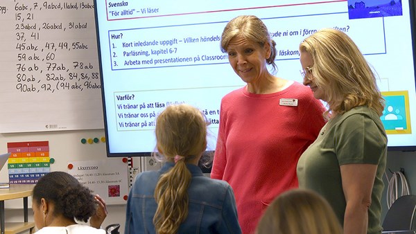 Skolministern Lotta Edholm i klassrum pratar med lärare och elever.